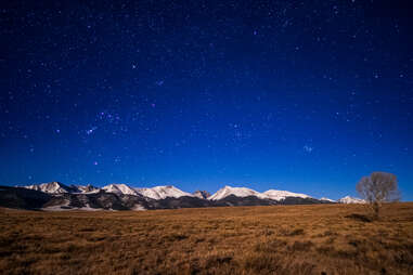 mountains and a field on a starry night