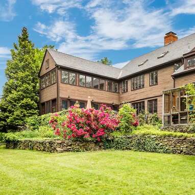 A renovated farmhouse with historical details and a charming pond