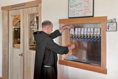 a monk pouring beer from a tap