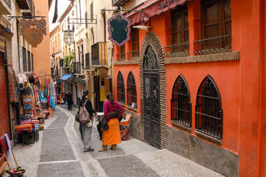 people walking down a narrow European street