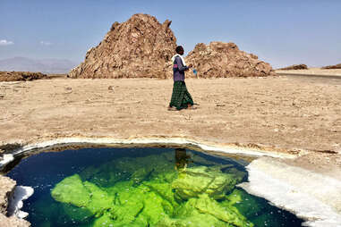 Tour Guide next to the green water on the salt lake in the Danakil Depression in Ethiopa