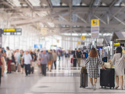 Woman carries luggage at the airport terminal