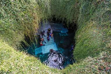 people swimming in an underground crystal spring