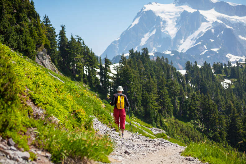 a person hiking along a ridge toward a mountain peak