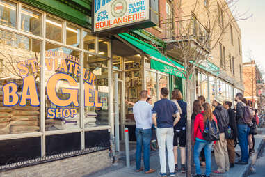 people lined up outside a bagel shop
