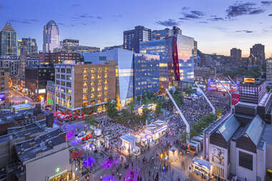 aerial view of crowds in the middle of a large city at dusk