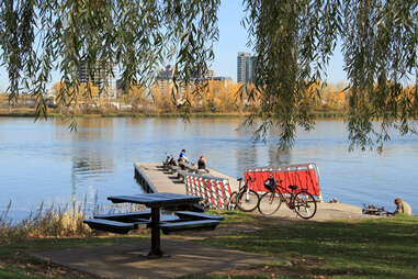 people sitting on a dock near a lake