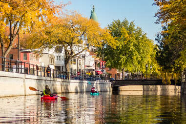 people canoeing down lachine canal in saint-henri neighborhood, montreal