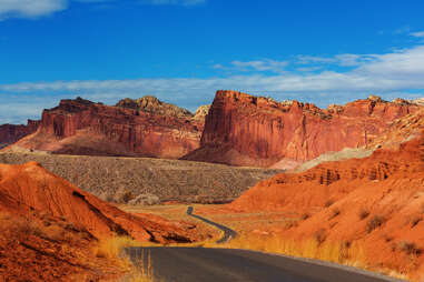 a road leading into a towering rock canyon