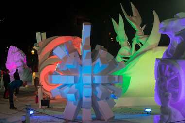 people observing enormous snow sculptures