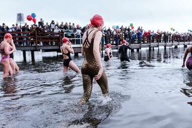 swimmers wading into an ice-cold lake