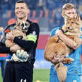 soccer players hold puppies