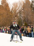 guy on barstool mounted on skis 