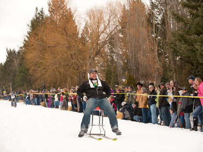 guy on barstool mounted on skis 