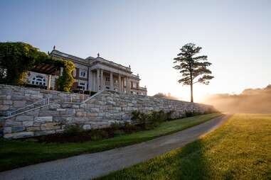 a mansion on a hill in the sunlight