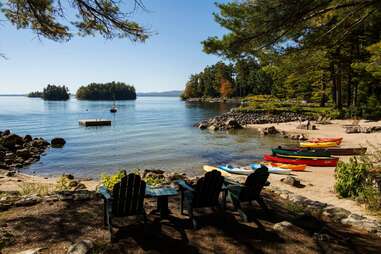 canoes and chairs on a lakeshore