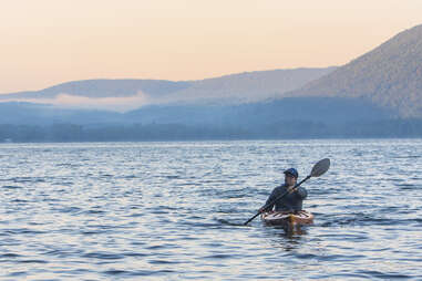 person canoeing across a lake