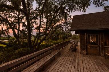 a rocking chair on a porch overlooking marshlands