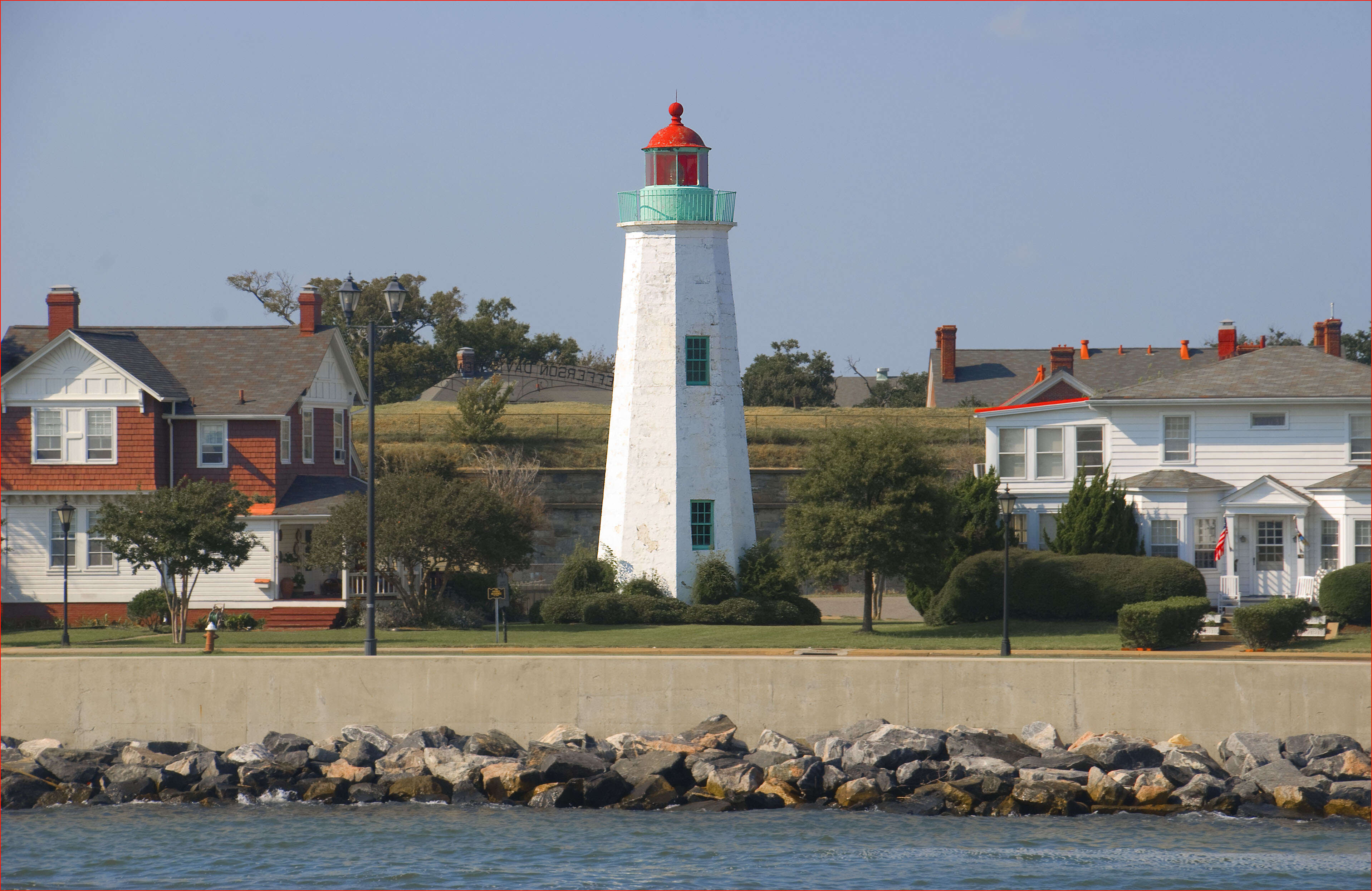 a lighthouse surrounded by colonial homes