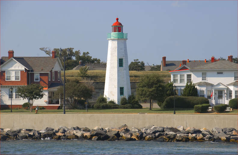 a lighthouse surrounded by colonial homes