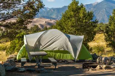 a green tent in a campsite 