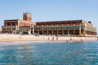 people on a beach near a large building