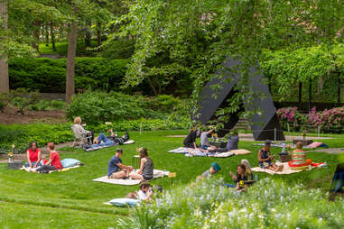 multiple groups of people having picnics in a sculpture garden