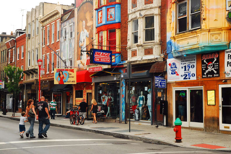 A family crosses South Street, an eclectic, funky shopping district in Philadelphia, Pennsylvania