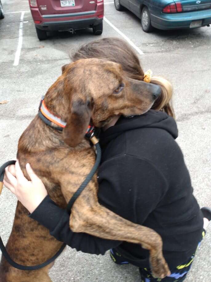 Shelter dog hugs girl in need