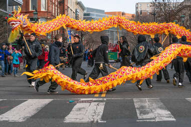 people leading a dragon during a lunar new year parade