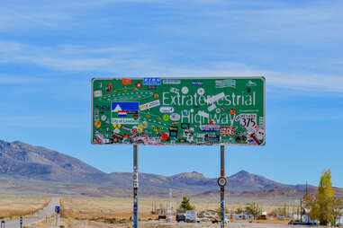 a highway sign for the Extraterrestrial Highway near desert mountains