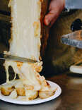 raclette cheese scraped over potatoes