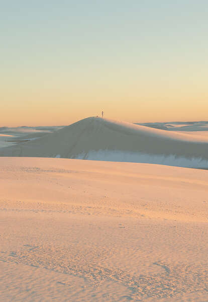 a person standing on a white sand dune