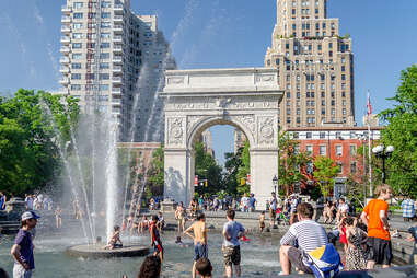 people near the Washington Square Arch and fountain in nyc on a sunny day