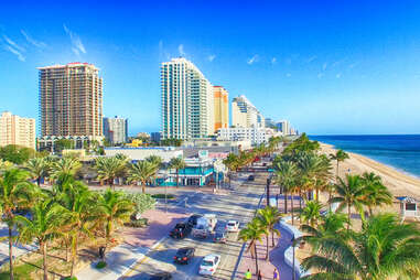 City aerial skyline, beach, and palm trees on a sunny morning
