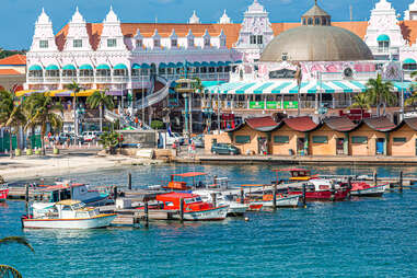 a large and colorful seaside city lined by boats in a bay