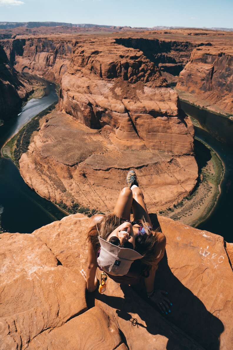 woman sitting at the edge of horseshoe bend