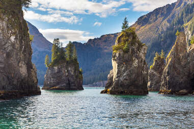 spire rocks in a lake near large mountains