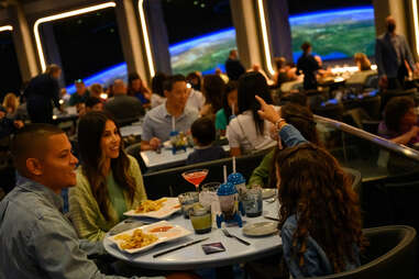 people eating in a spaceship restaurant with a view of earth