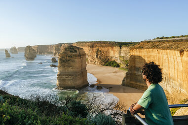 person overlooking sea stacks by the ocean
