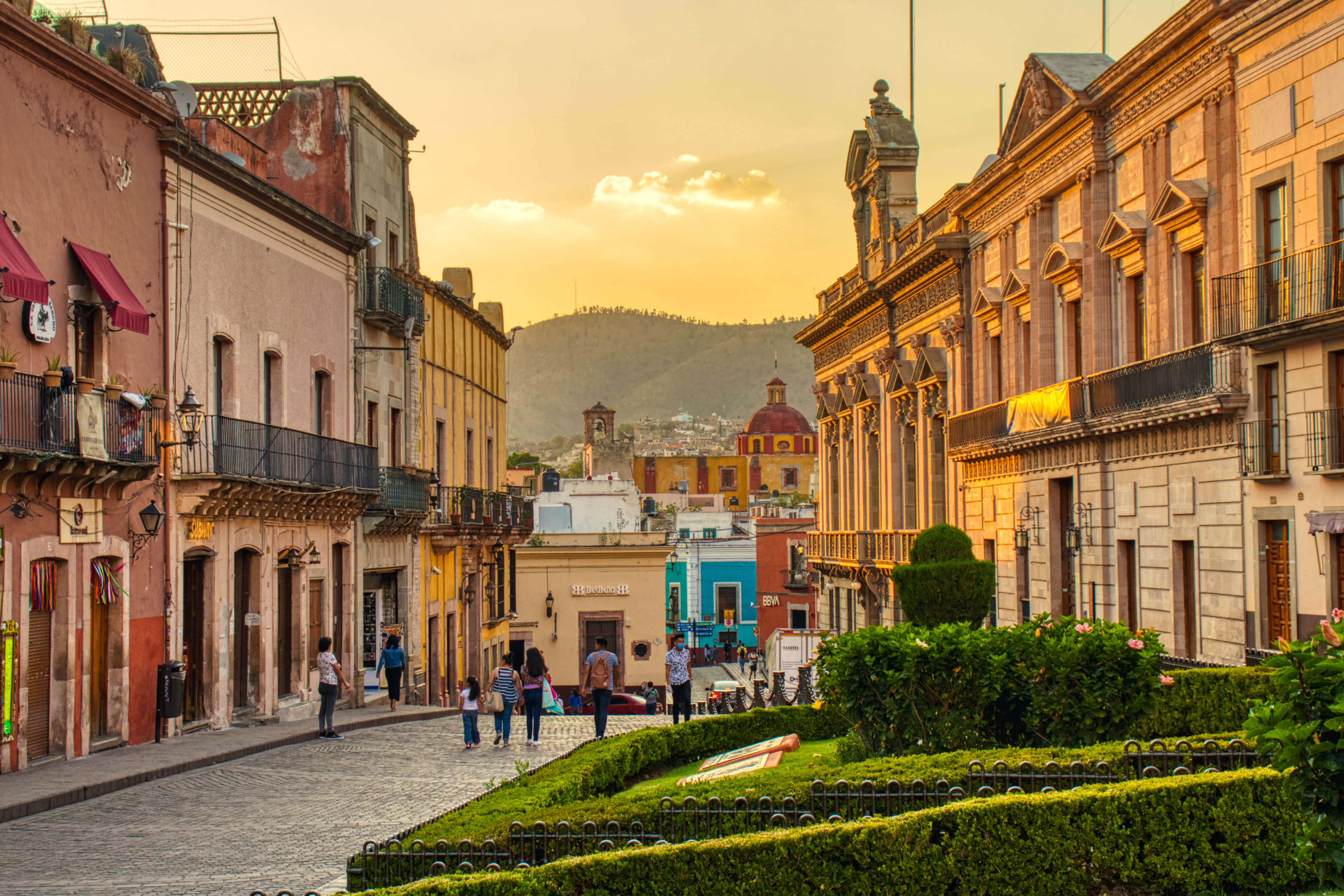 people walking through a beautiful town at sunset