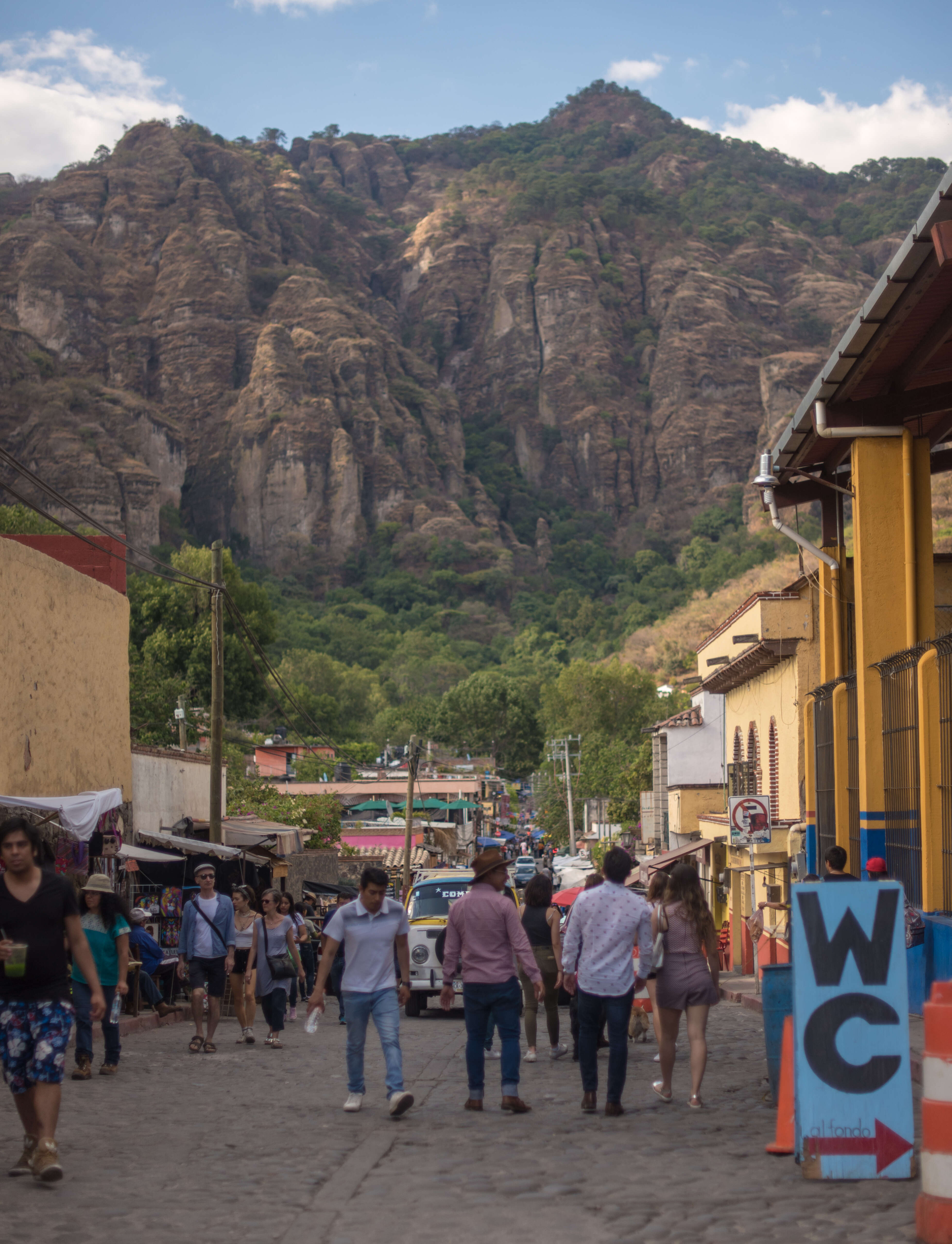 people walking the streets of an ancient mountainside town