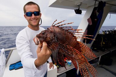 Man holding lionfish