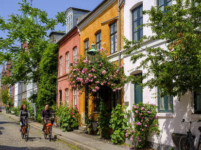 A couple riding bicycles along street in Denmark, Copenhagen