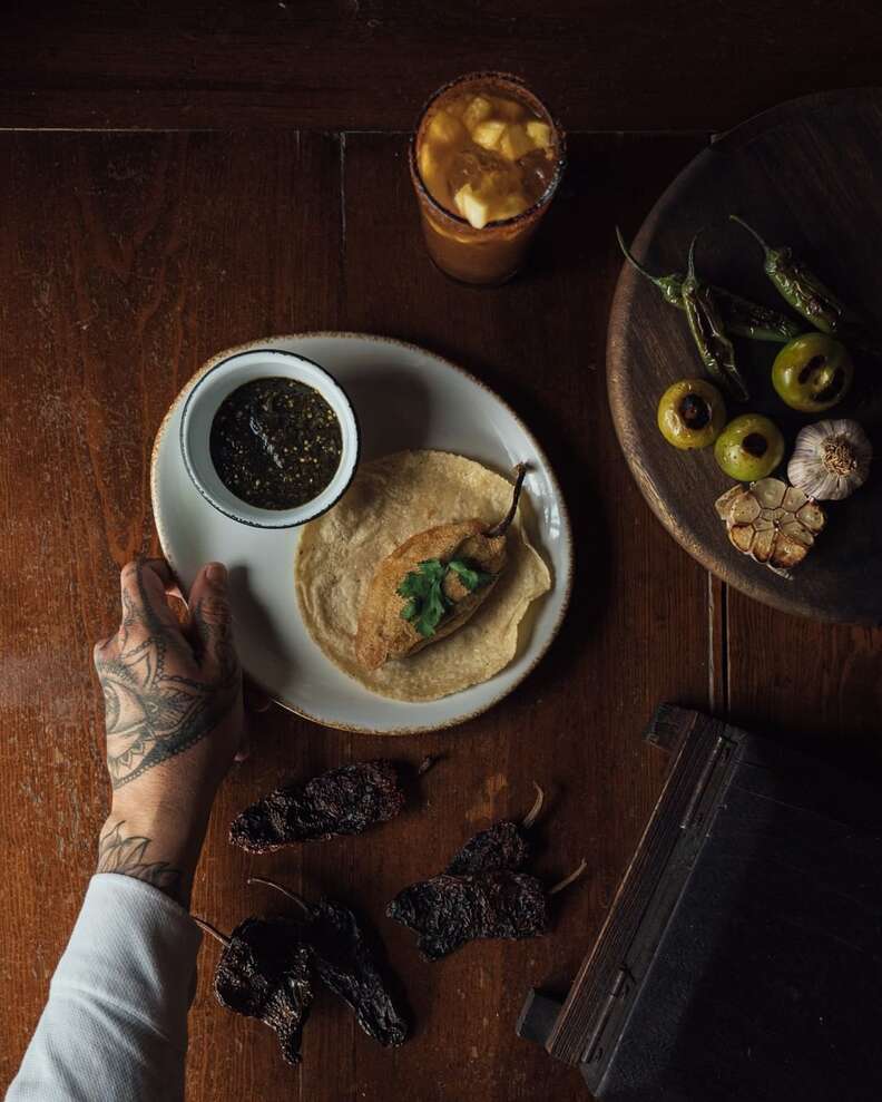 A person holds a plate with tacos