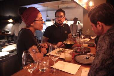 People in a restaurant sitting at a table with food and drink