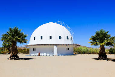 unusual dome structure and palms in the desert