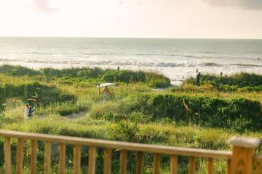 surfers walking along folly beach