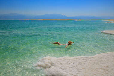 woman floating in the idyllic waters of the Dead Sea