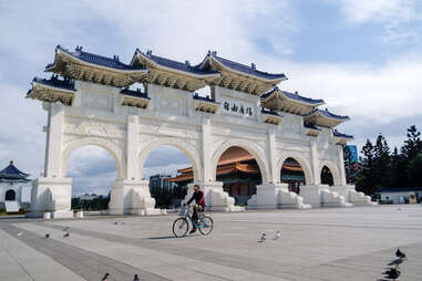 A cyclist rides past the Chiang Kai-shek memorial hall entrance in Taipei